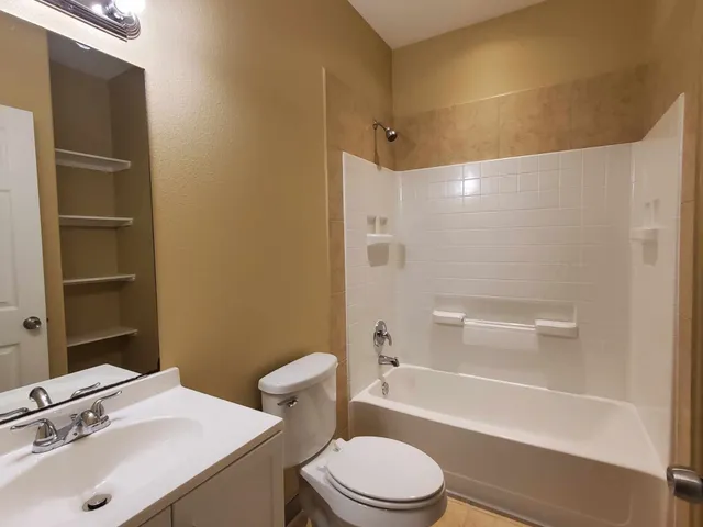 a bathroom with a sink mirror toilet and bathtub