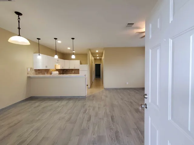 a view of a kitchen counter top space wooden floor and a ceiling fan