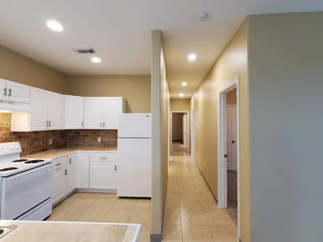 a kitchen with granite countertop a refrigerator and a sink
