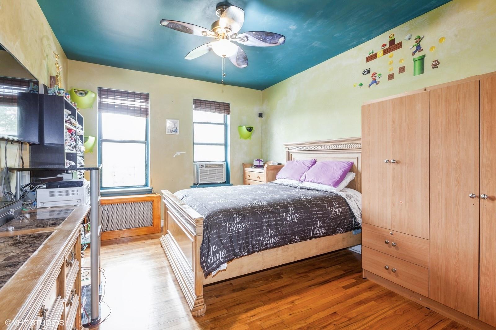 1670 Longfellow Avenue, Unit 6J Bronx, NY 10460 - Photo 6 of 15 a bedroom with a large bed and a chandelier