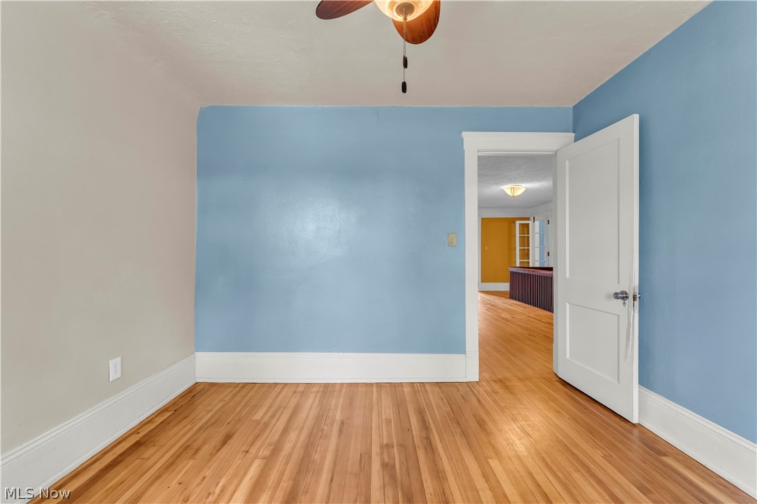 17406 Nottingham Road Cleveland, OH 44119 - Photo 28 of 45 Wood-finish flooring, white trim, ceiling fan with light, and paneled interior door