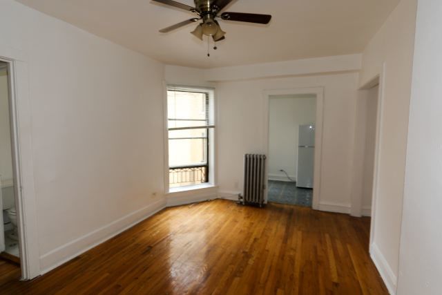4604 North Beacon Street, Unit 3E Chicago, IL 60640 - Photo 11 of 13 a view of empty room with wooden floor and fan
