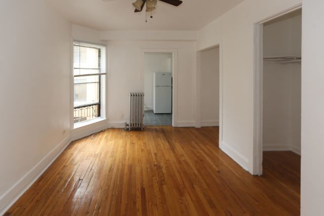 4604 North Beacon Street, Unit 3E Chicago, IL 60640 - Photo 10 of 13 an empty room with wooden floor and windows