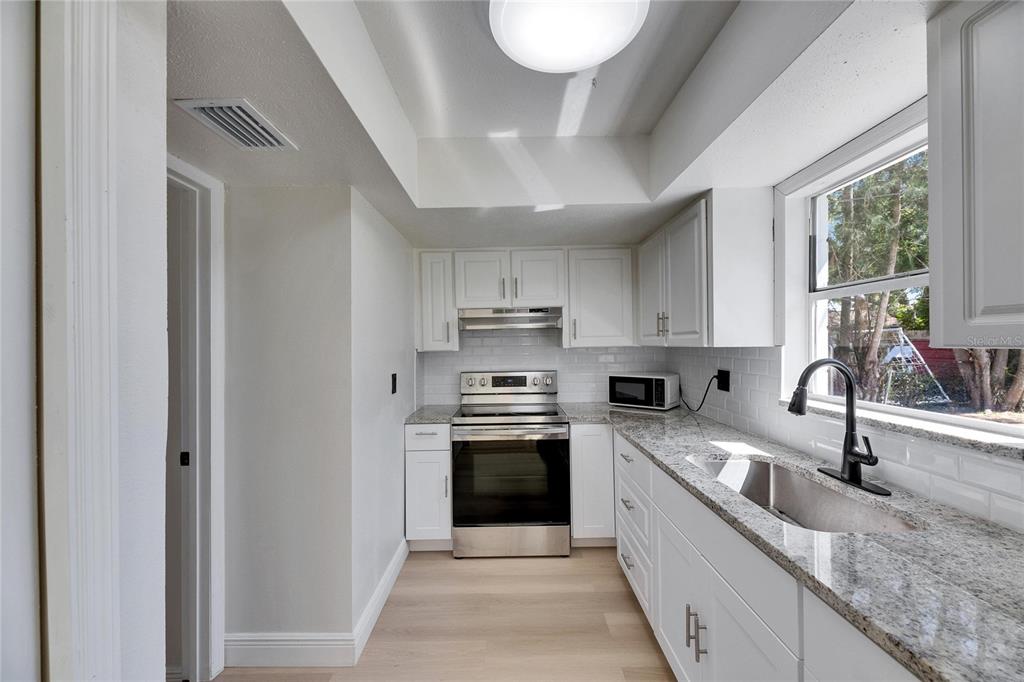 564 Florida Circle South Apollo Beach, FL 33572 - Photo 22 of 46 a kitchen with stainless steel appliances granite countertop a sink and a stove