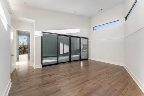 a view of an empty room with window and a livingroom