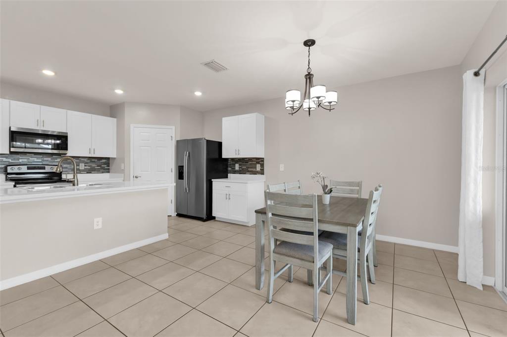 4219 Manatee Lane Punta Gorda, FL 33980 - Photo 15 of 56 a kitchen with stainless steel appliances kitchen island granite countertop a dining table chairs and a refrigerator