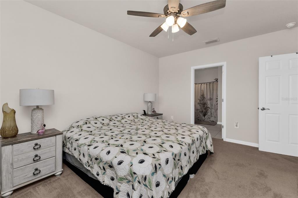 4219 Manatee Lane Punta Gorda, FL 33980 - Photo 19 of 56 a bedroom with a large bed and a chandelier