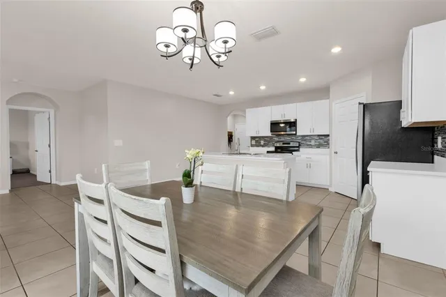 a bedroom with a large bed and a chandelier
