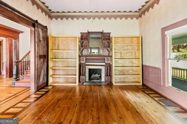 a view of staircase with lots of frames on wall and wooden floor