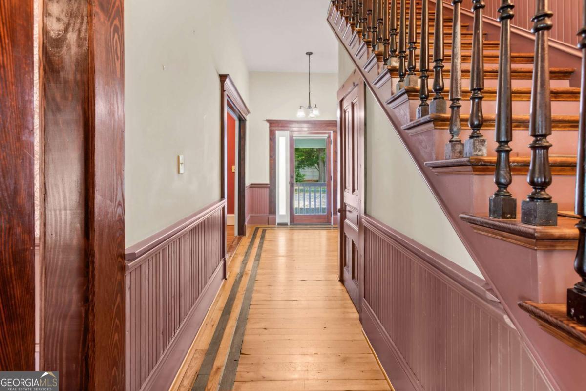 212 Yancey Road Arnoldsville, GA 30619 - Photo 17 of 50 a view of staircase with lots of frames on wall and wooden floor