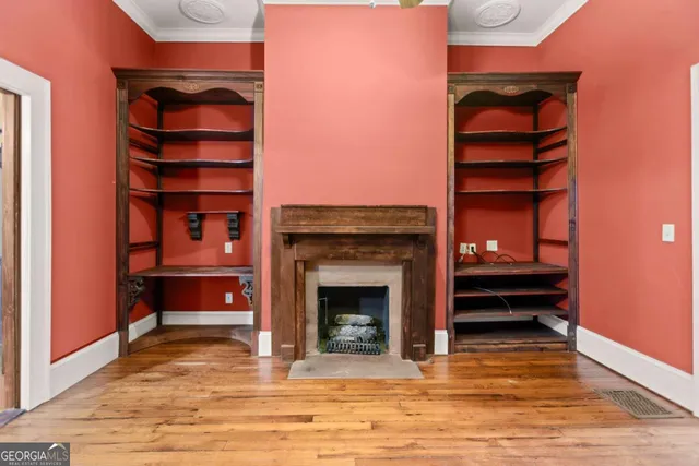 a view of an empty room with a fireplace and a window