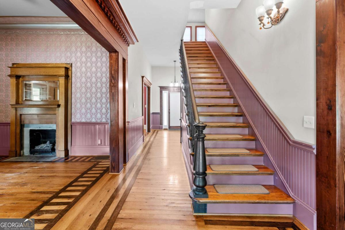 212 Yancey Road Arnoldsville, GA 30619 - Photo 9 of 50 a view of staircase with wooden floor and a fireplace