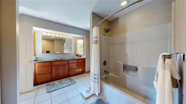 a bathroom with a granite countertop sink mirror and a bathtub
