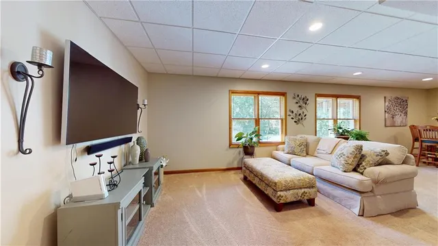 a living room with furniture a flat screen tv and a large window