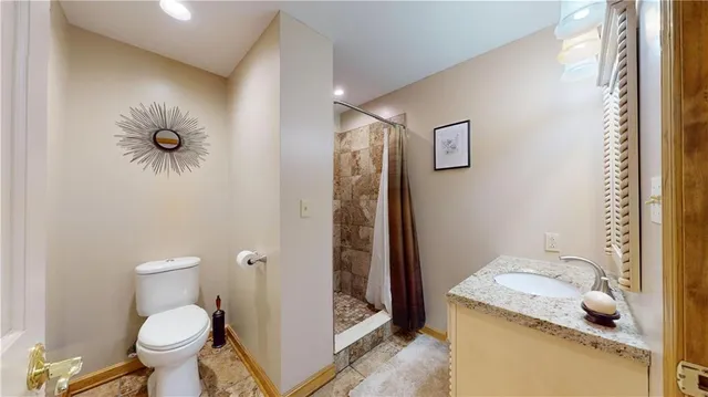 a bathroom with a granite countertop toilet and a sink