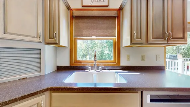 a kitchen with granite countertop white cabinets and a window
