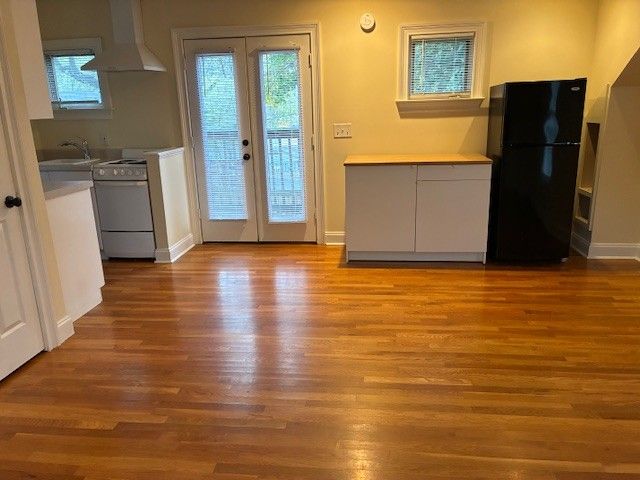 an empty room with wooden floor and cabinet