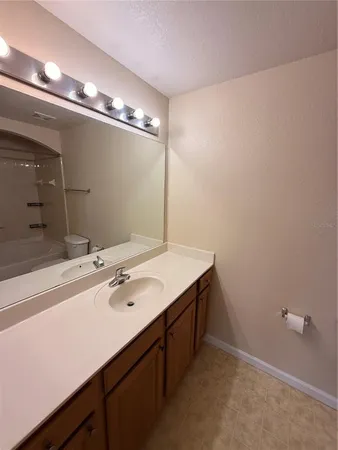 a white toilet sitting next to a bathroom sink and vanity