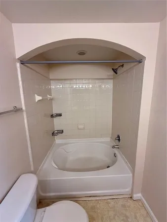 an empty room with wooden floor chandelier fan and windows