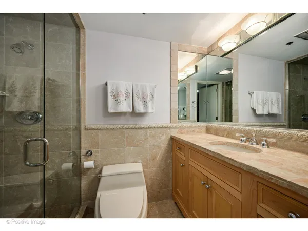 a bathroom with a granite countertop sink a mirror and a shower