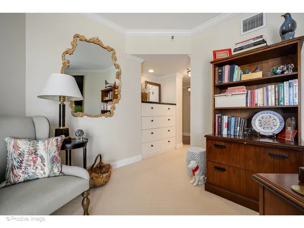 a living room with furniture and a baby crib