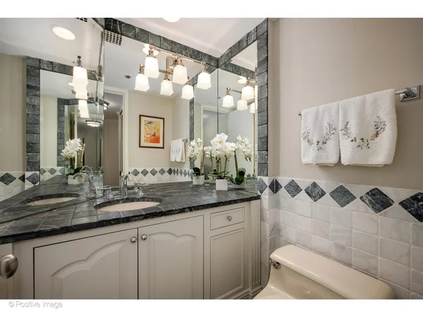 a bathroom with a sink vanity granite and a mirror
