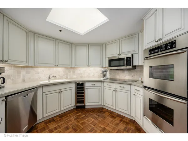 a kitchen with granite countertop white cabinets stainless steel appliances and a sink