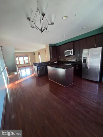 a living room with stainless steel appliances furniture and a flat screen tv
