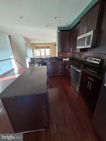 a kitchen with stainless steel appliances wooden cabinets and a stove top oven