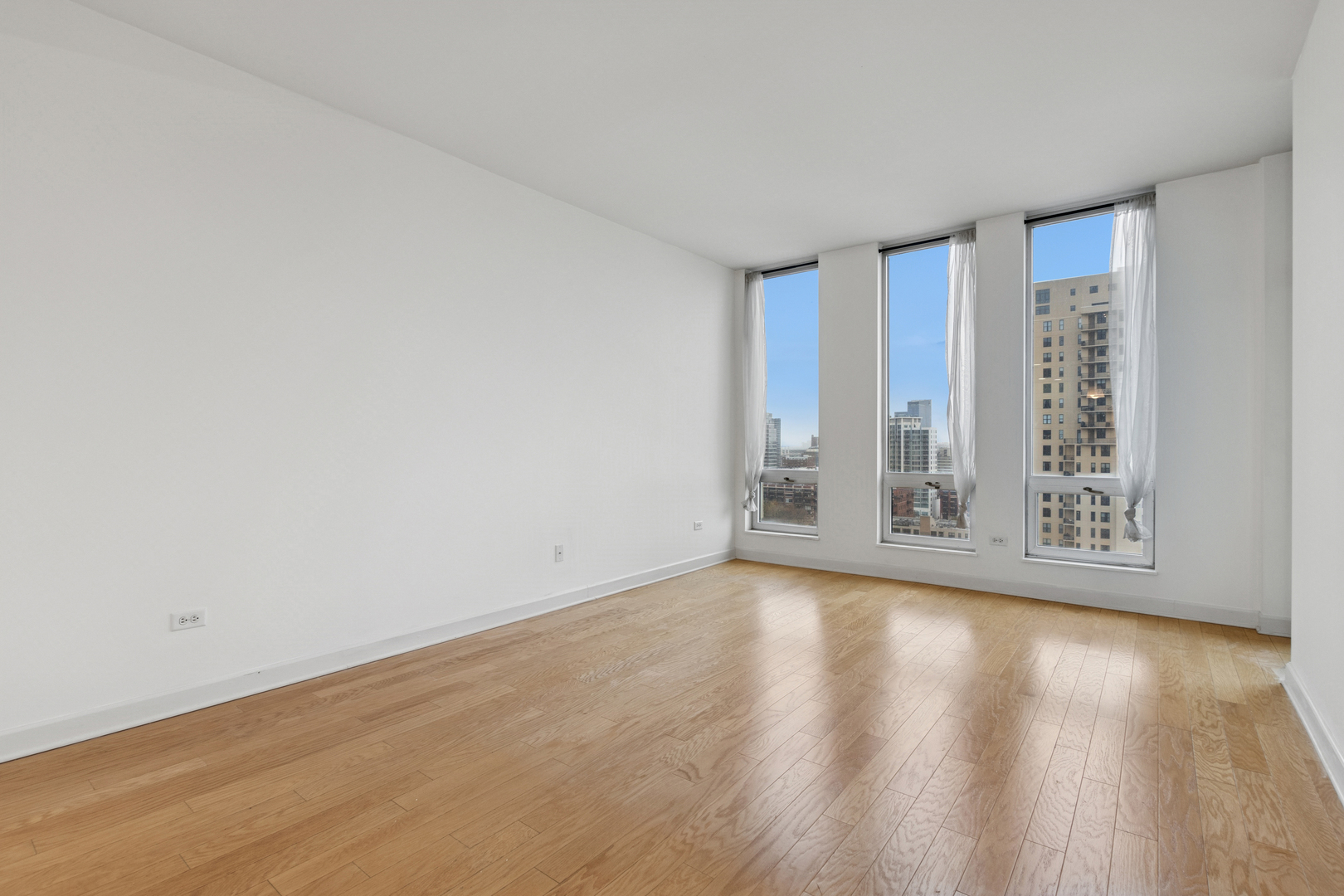 1400 South Michigan Avenue, Unit 1708 Chicago, IL 60605 - Photo 7 of 20 a view of an empty room with wooden floor and a window