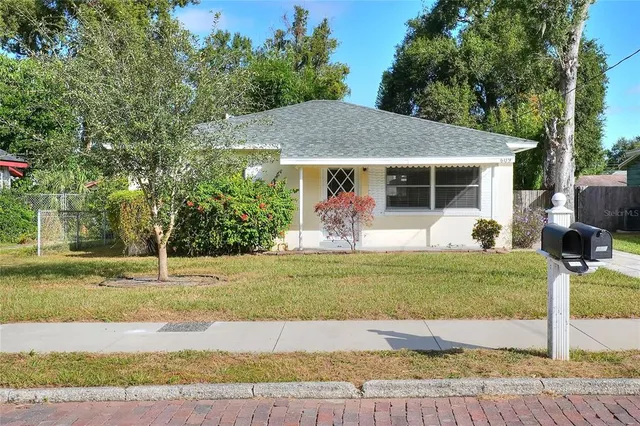 a view of a house with backyard and trees