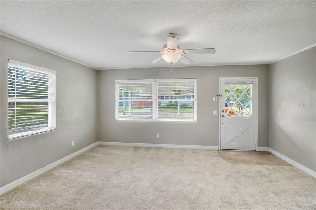 609 West Park Street Lakeland, FL 33803 - Photo 5 of 30 an empty room with windows and chandelier fan
