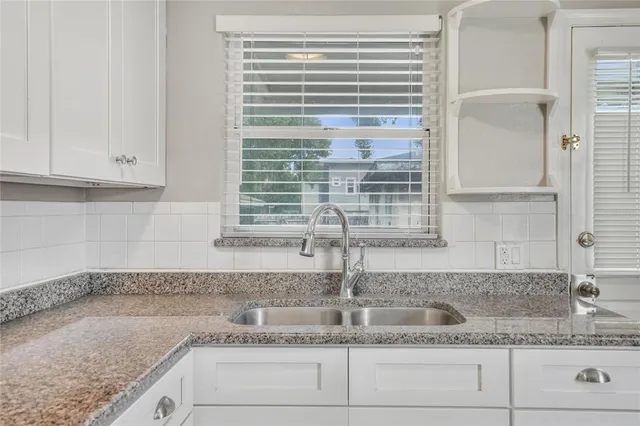 a kitchen with granite countertop a sink and a window