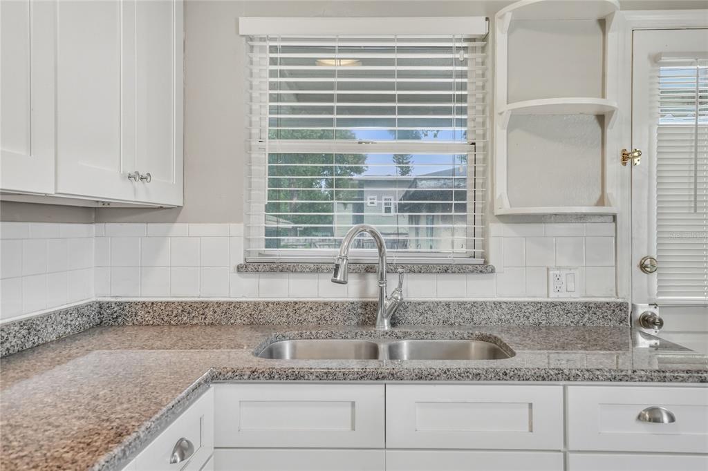 609 West Park Street Lakeland, FL 33803 - Photo 9 of 30 a kitchen with granite countertop a sink and a window