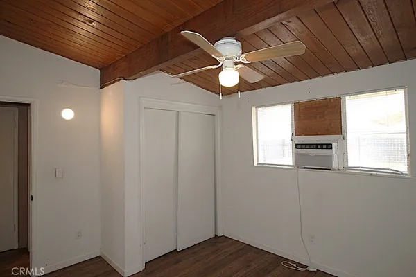a view of empty room with window and wooden floor