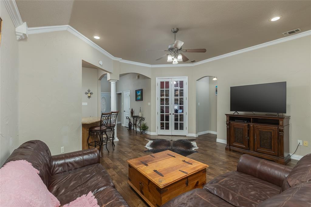 257 Reatta Drive Decatur, TX 76234 - Photo 11 of 39 a living room with furniture a flat screen tv and kitchen view
