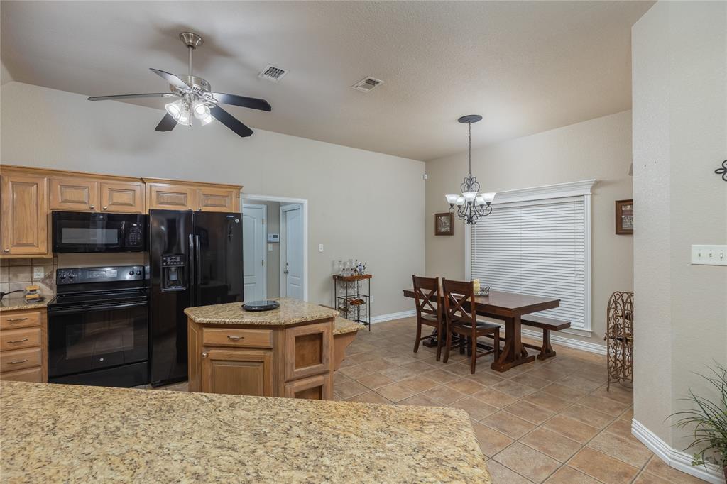 257 Reatta Drive Decatur, TX 76234 - Photo 16 of 39 a kitchen with stainless steel appliances kitchen island granite countertop a stove refrigerator and cabinets