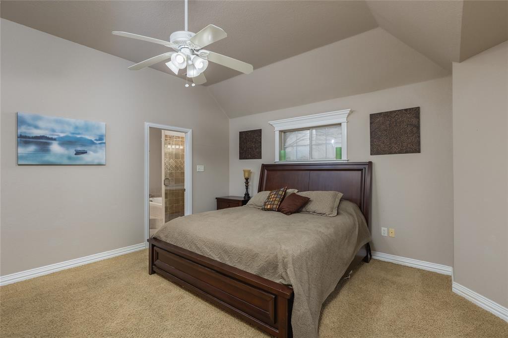 257 Reatta Drive Decatur, TX 76234 - Photo 21 of 39 a bedroom with a large bed and a chandelier