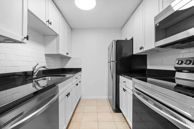 a kitchen with stainless steel appliances a sink stove and microwave