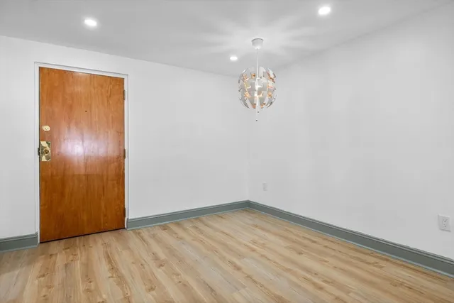 a view of empty room with wooden floor and window