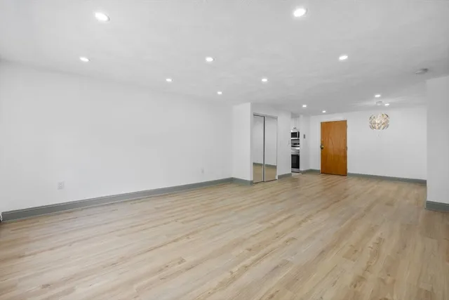 a view of an empty room with wooden floor