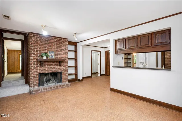a view of empty room with fireplace and cabinet
