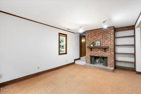 an empty room with a fireplace and window