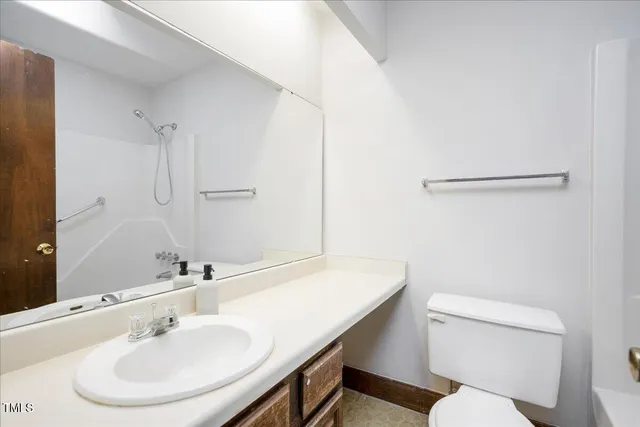 a bathroom with a sink a toilet a mirror and shower