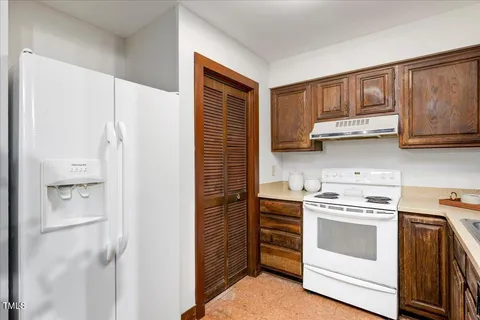 a kitchen with stainless steel appliances granite countertop a refrigerator and a stove top oven