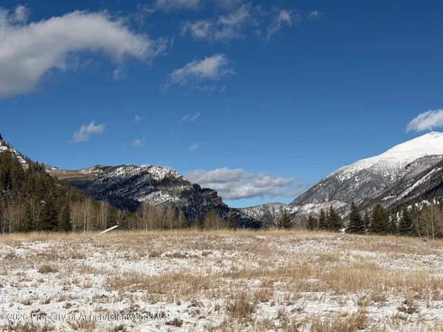 a view of a dry yard with mountains in the background