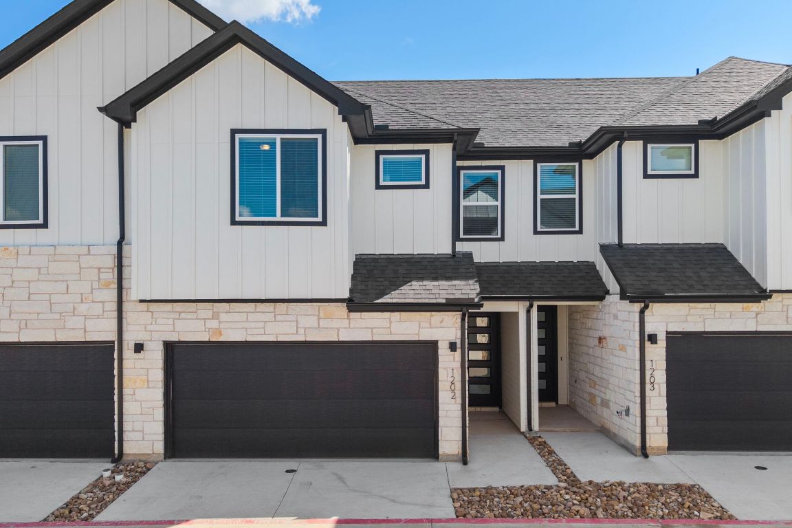 2600 Gattis School Road, Unit 1202 Round Rock, TX 78664 - Photo 1 of 24 View of front of home with roof with shingles, stone siding, a garage, and board and batten siding