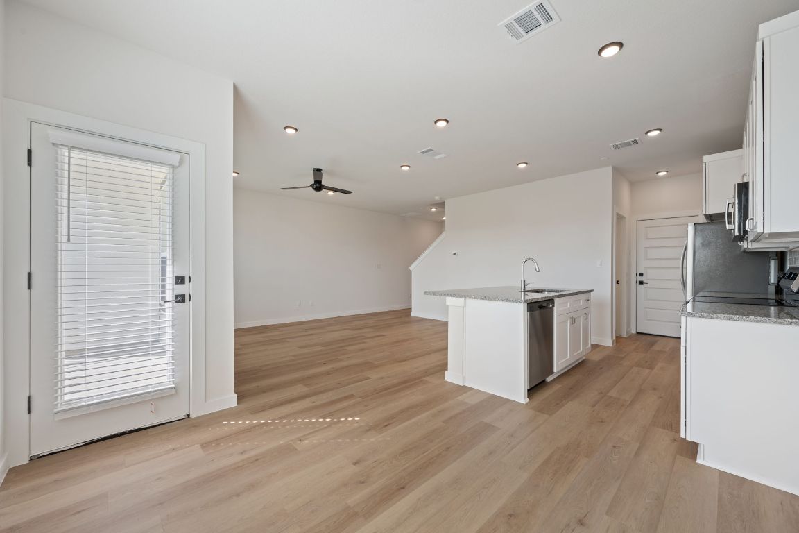 2600 Gattis School Road, Unit 1202 Round Rock, TX 78664 - Photo 24 of 24 Kitchen featuring white cabinets, light stone counters, open floor plan, and recessed lighting