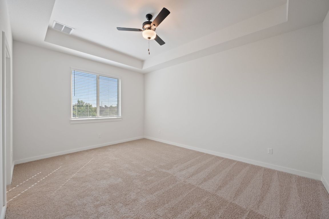 2600 Gattis School Road, Unit 1202 Round Rock, TX 78664 - Photo 11 of 24 Unfurnished room featuring a raised ceiling, light carpet, and ceiling fan