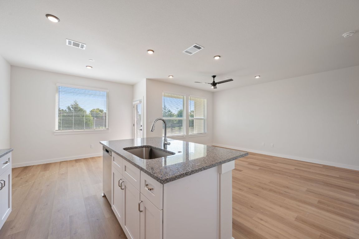 2600 Gattis School Road, Unit 1202 Round Rock, TX 78664 - Photo 23 of 24 Kitchen with white cabinetry, light wood-style floors, dark stone countertops, open floor plan, and recessed lighting